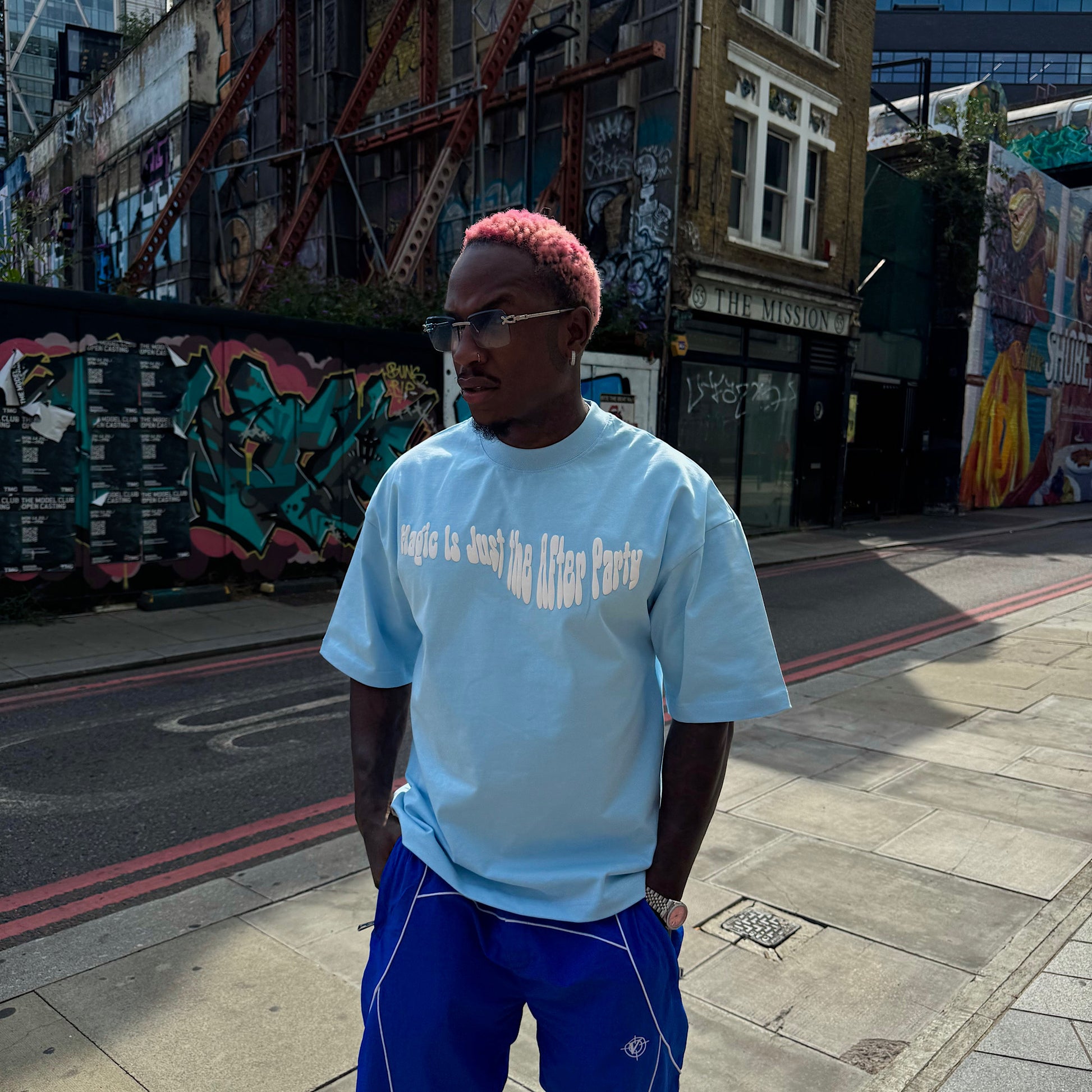 Model wearing the Wizardry After Party oversized heavyweight baby blue graphic T-shirt featuring the white ‘Magic Is Just the After Party’ chest print