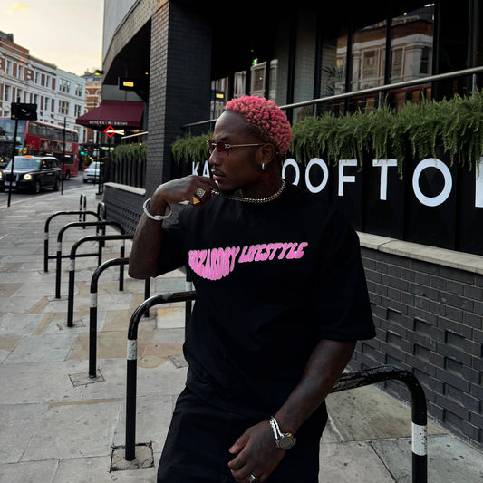 Model wearing the Wizardry Lifestyle oversized heavyweight black graphic T-shirt featuring the pink ‘Lifestyle’ chest print